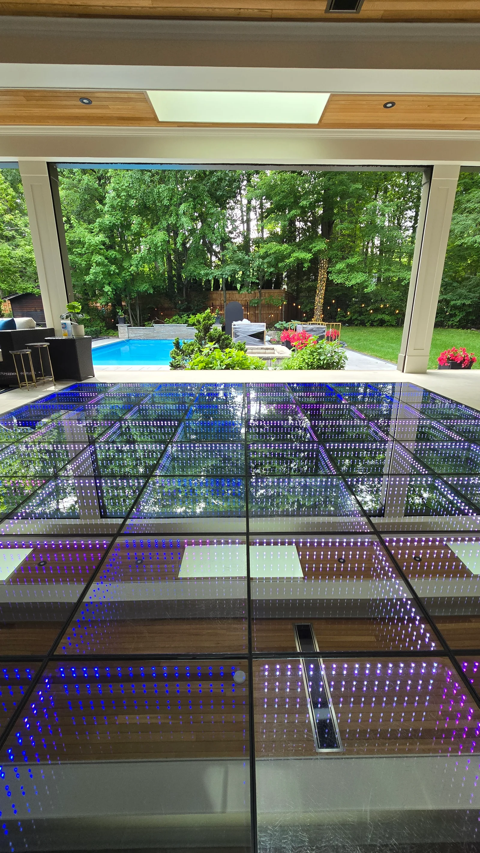 Blue infinity LED dance floor beneath a covered poolside pavilion