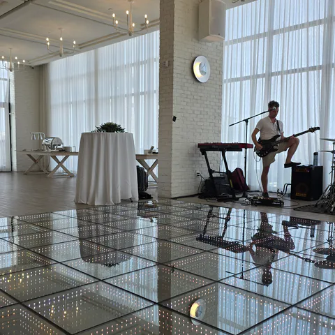 Band and infinity LED dance floor inside a bright event space