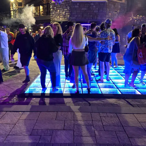 Guests dancing on an outdoor infinity LED dance floor