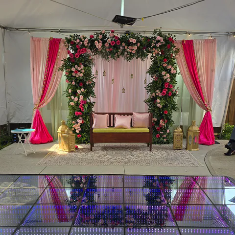 Floral wedding backdrop beside an infinity LED dance floor