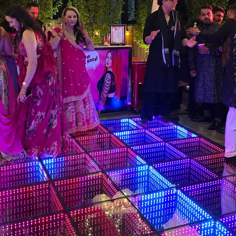 Guests around a colorful infinity LED dance floor