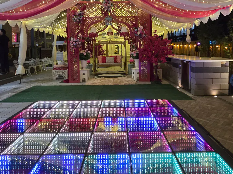 Full-color infinity LED dance floor beneath a decorated event tent